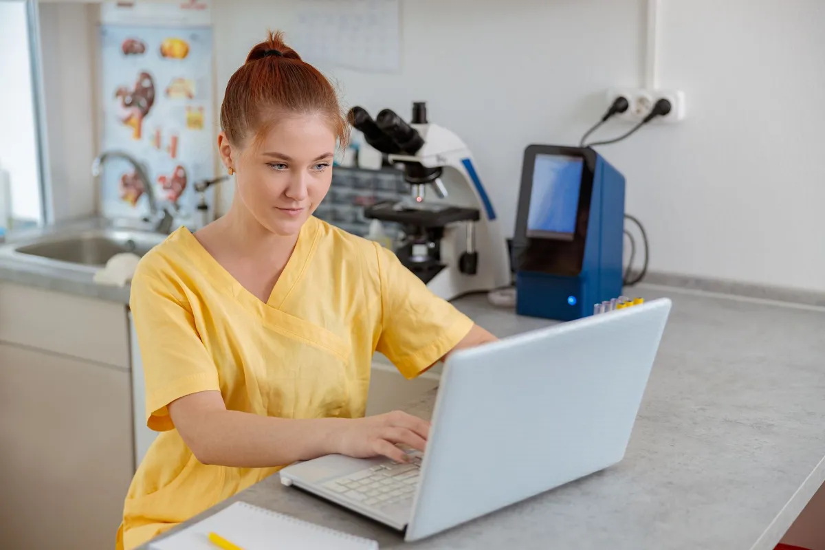 Veterinary professional using a laptop in a clinical workspace featured in SVMG veterinary digital marketing and future growth strategy.